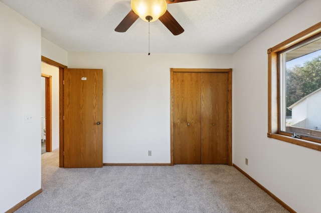 unfurnished bedroom featuring multiple windows, a closet, ceiling fan, and light colored carpet