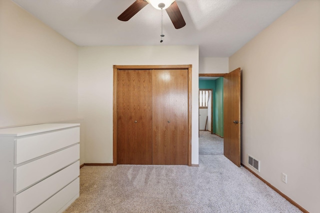 unfurnished bedroom featuring a closet, ceiling fan, and light colored carpet