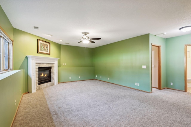 unfurnished living room featuring a brick fireplace, a textured ceiling, ceiling fan, and carpet