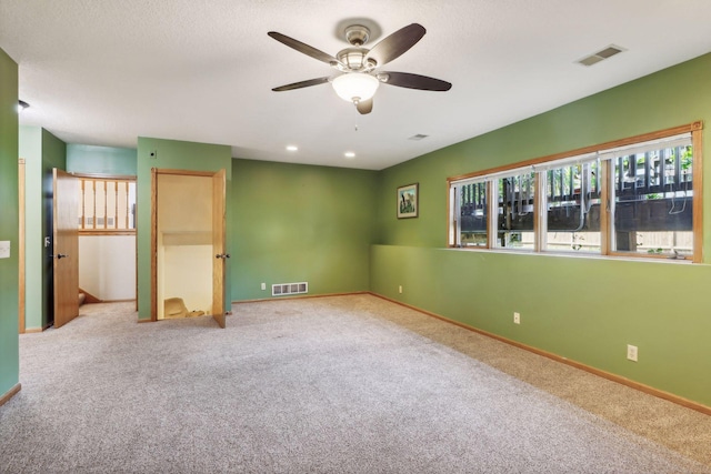 spare room with ceiling fan and carpet