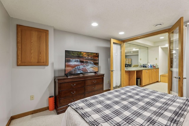 carpeted bedroom featuring sink and a textured ceiling