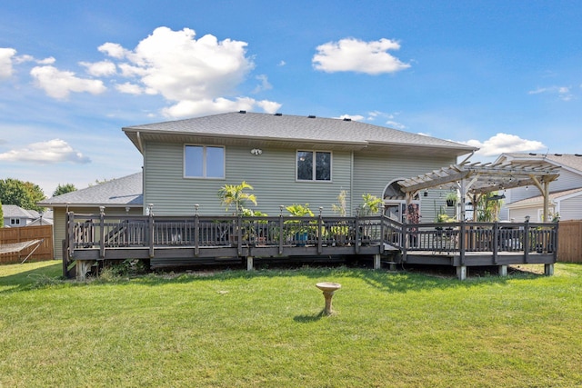 rear view of house with a pergola, a wooden deck, and a lawn