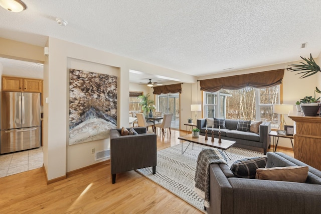 living room with light wood-type flooring and a textured ceiling