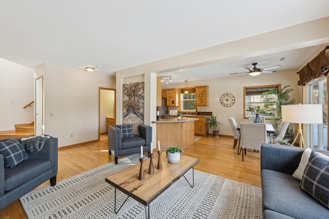 living room with light hardwood / wood-style flooring and ceiling fan