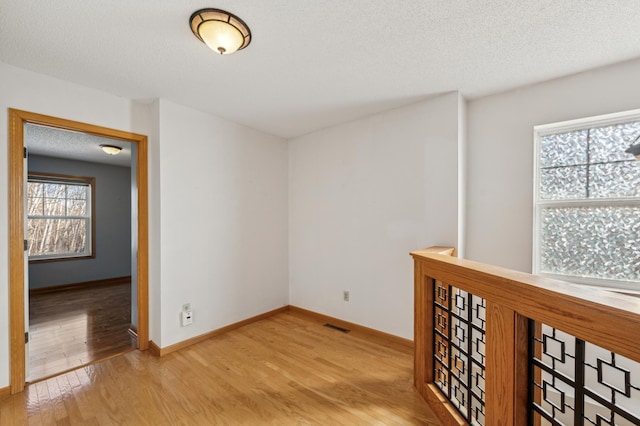 spare room featuring a textured ceiling and light wood-type flooring