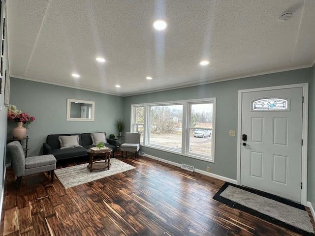 entryway with crown molding, dark hardwood / wood-style floors, and a textured ceiling