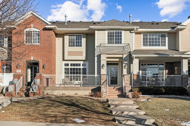 view of front facade featuring a balcony and a front yard