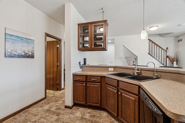 kitchen featuring pendant lighting, sink, black dishwasher, a textured ceiling, and kitchen peninsula