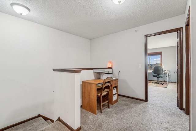 office space with light carpet and a textured ceiling