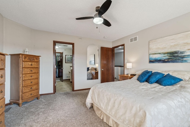 bedroom with a textured ceiling, ceiling fan, and light carpet