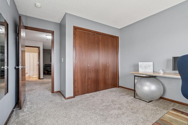 unfurnished office featuring light colored carpet and a textured ceiling