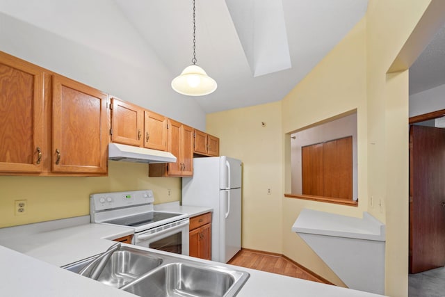 kitchen with white appliances, decorative light fixtures, lofted ceiling with skylight, and sink