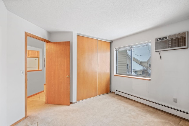 unfurnished bedroom featuring a wall mounted AC, light carpet, a closet, and baseboard heating