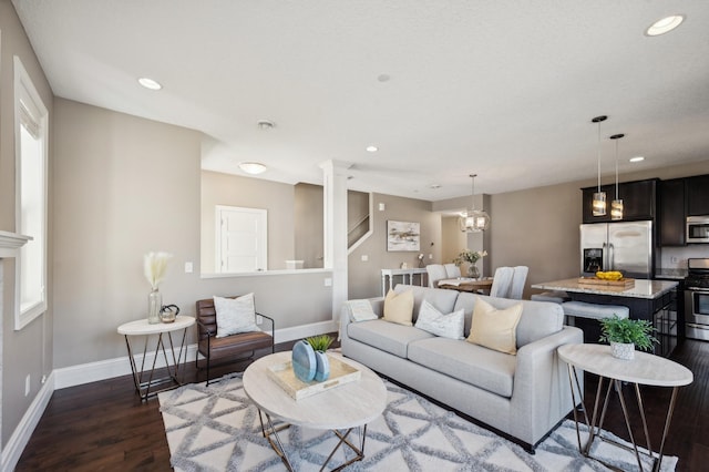 living area with a chandelier, dark wood-type flooring, recessed lighting, and baseboards