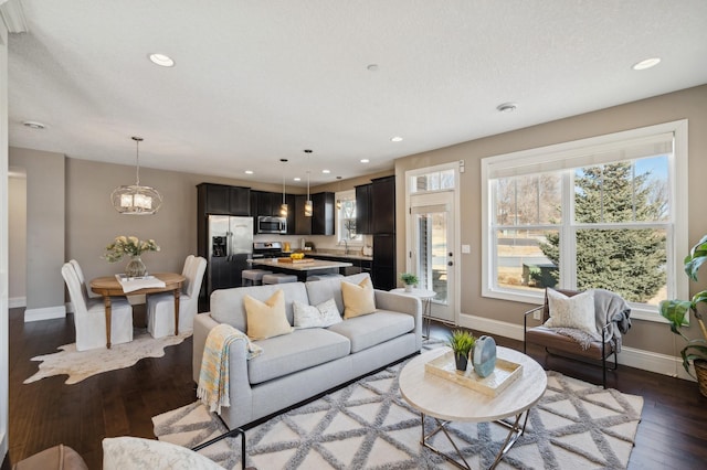 living room featuring recessed lighting, hardwood / wood-style flooring, and baseboards