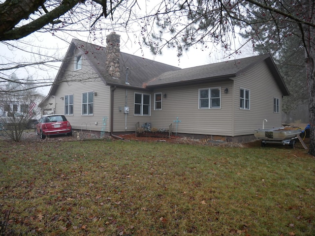 rear view of property featuring a lawn