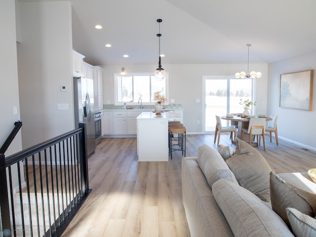 living room with light hardwood / wood-style floors, a notable chandelier, and sink