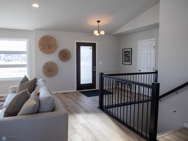 foyer with vaulted ceiling and light hardwood / wood-style flooring