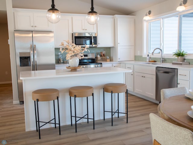 kitchen with stainless steel appliances, white cabinetry, sink, and tasteful backsplash