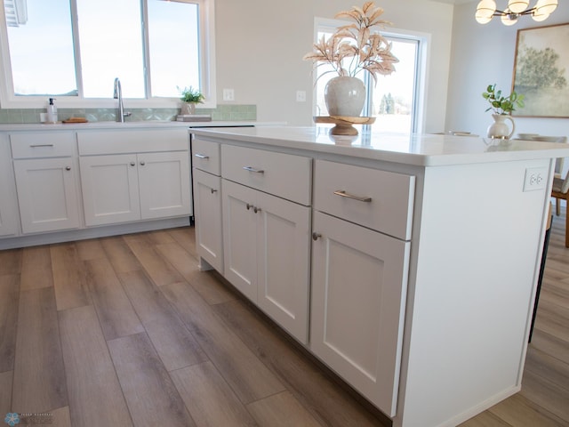 kitchen featuring a kitchen island, white cabinetry, a wealth of natural light, and hanging light fixtures