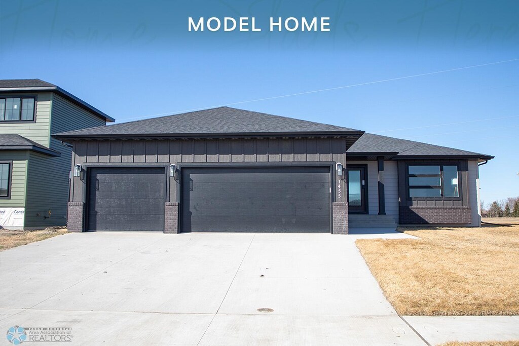 1455 66th Ave S, Fargo, ND 58104 - prairie-style house featuring an attached garage, board and batten siding, and roof with shingles
