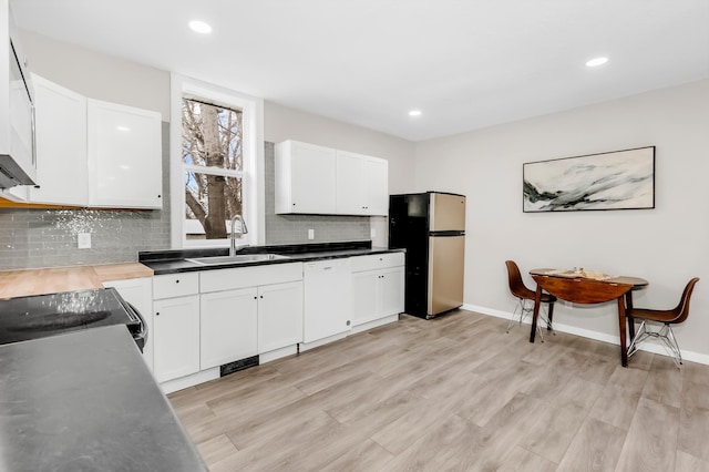 kitchen with white cabinets, dishwasher, stainless steel fridge, and sink