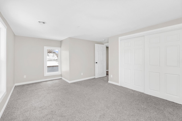 unfurnished bedroom with a closet and carpet floors