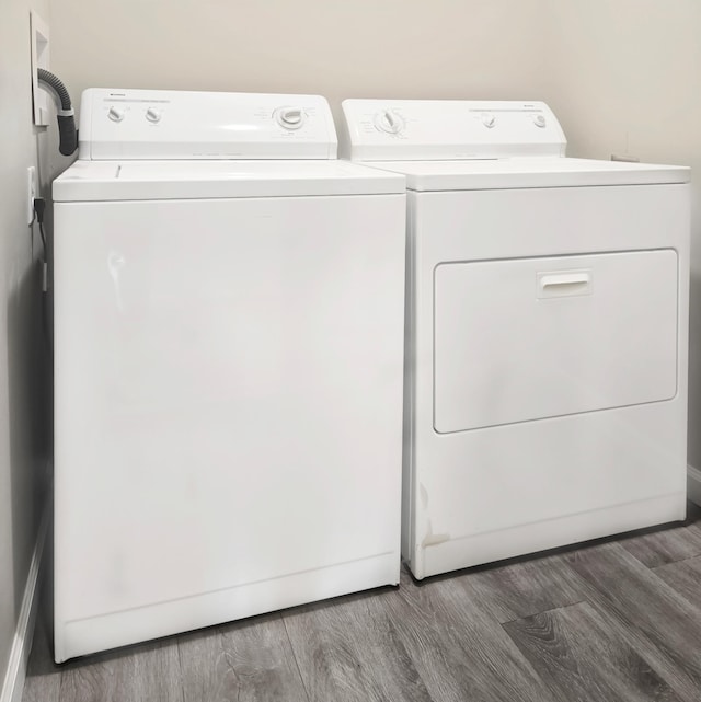 laundry room with washing machine and dryer and dark wood-type flooring