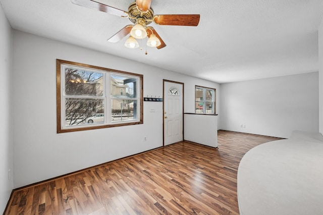 spare room featuring wood-type flooring, a textured ceiling, and ceiling fan