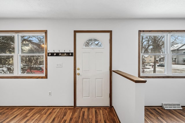 entrance foyer with dark wood-type flooring and a textured ceiling