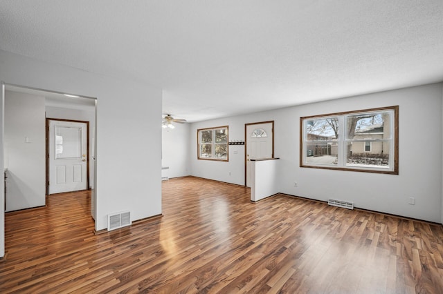 unfurnished room featuring ceiling fan, hardwood / wood-style flooring, and a textured ceiling