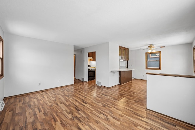 unfurnished living room featuring ceiling fan and hardwood / wood-style floors