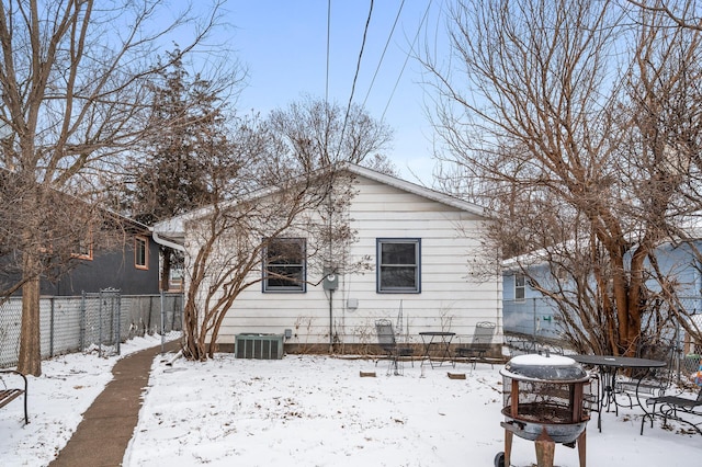 snow covered property with cooling unit and an outdoor fire pit