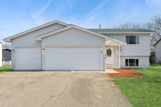 view of front of house featuring a front lawn, concrete driveway, and a garage