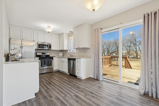 kitchen with white cabinetry, dark wood-type flooring, appliances with stainless steel finishes, and a sink