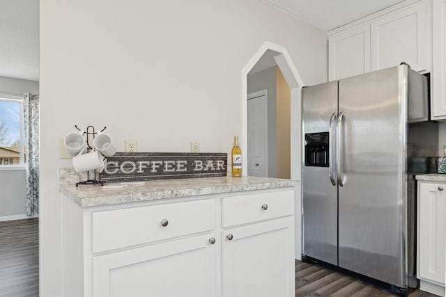 kitchen featuring stainless steel fridge, white cabinets, light countertops, baseboards, and dark wood-style flooring