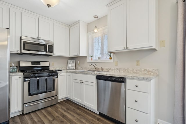 kitchen with dark wood finished floors, a sink, stainless steel appliances, light countertops, and white cabinets