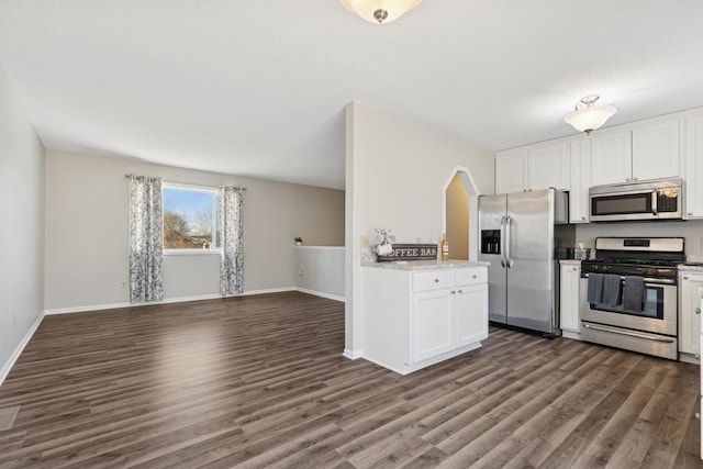 kitchen with baseboards, dark wood finished floors, white cabinets, appliances with stainless steel finishes, and open floor plan