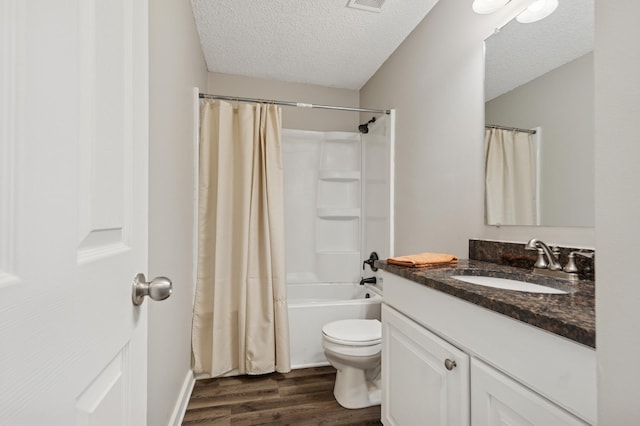 full bath featuring toilet, vanity, wood finished floors, shower / bath combination with curtain, and a textured ceiling