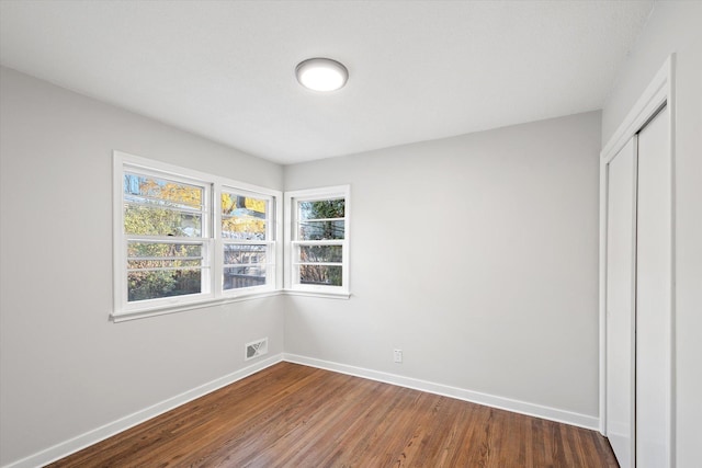 unfurnished bedroom featuring wood-type flooring and a closet