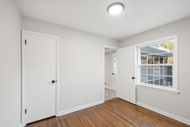 unfurnished bedroom with dark hardwood / wood-style flooring