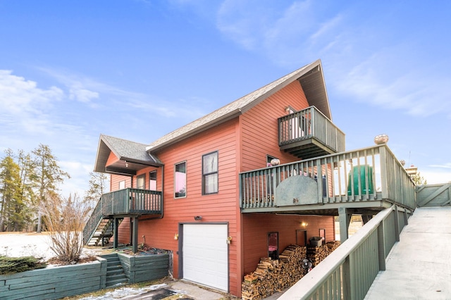 back of property featuring a balcony and a garage