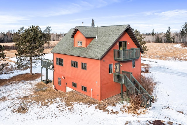 snow covered property featuring a balcony