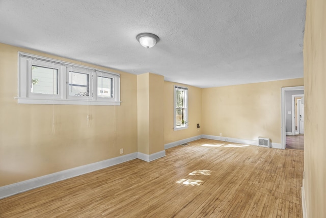 empty room featuring wood-type flooring and a textured ceiling