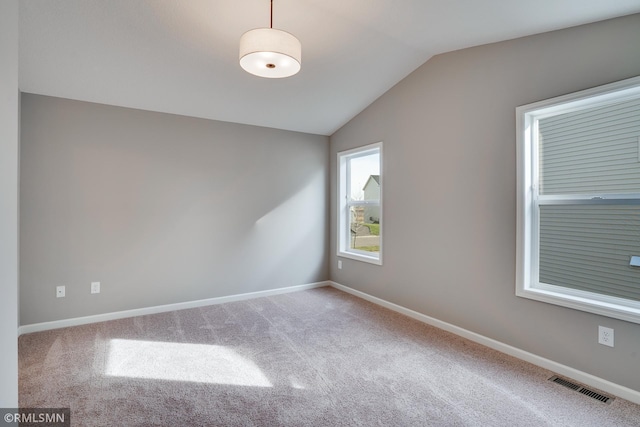 carpeted spare room featuring lofted ceiling