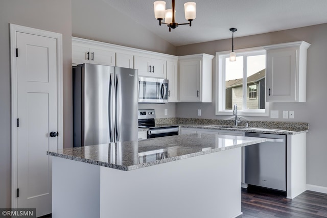 kitchen with sink, white cabinetry, a center island, hanging light fixtures, and appliances with stainless steel finishes