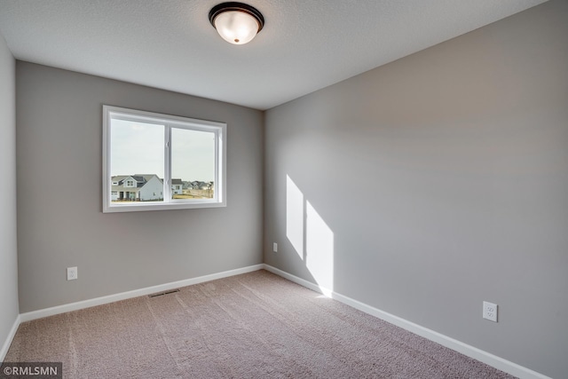 spare room with carpet floors and a textured ceiling