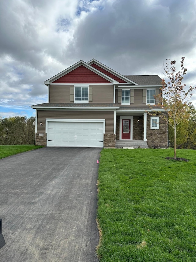 craftsman house featuring a garage, stone siding, a front yard, and driveway