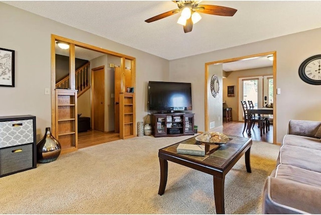 living room with carpet flooring, a textured ceiling, and ceiling fan