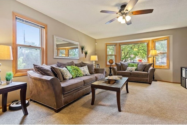 living room featuring carpet flooring, ceiling fan, and a textured ceiling